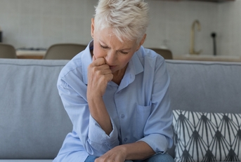 upset older woman sit on sofa manages finances