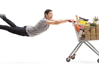 man being pulled by a shopping cart full of groceries