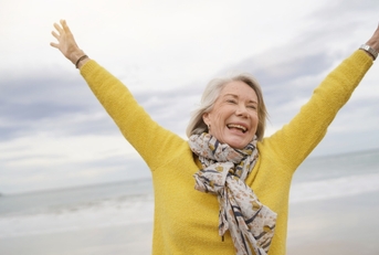 happy senior woman holding hands in air outdoor