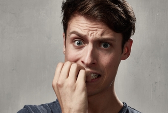 young man biting his nails in exhaustion