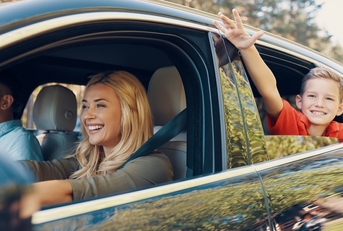 Parents driving a car with a child in the back seat