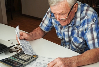 senior man sitting at the table and calculating finances
