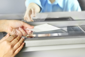 A woman is handing a check to cash it out