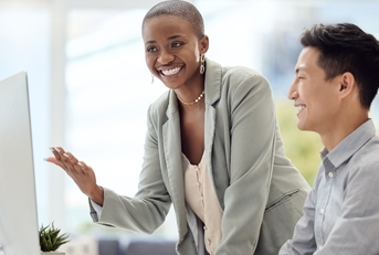 woman training a male employee in the office