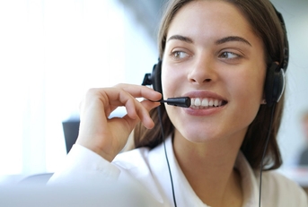 beautiful woman at workplace talking to customer on headset