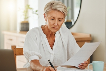 senior woman with notebook writing budget plan
