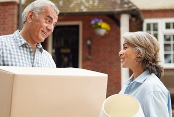 mature couple carrying boxes on moving day