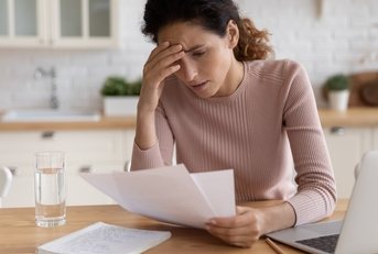 stressed millennial female freelancer scratching forehead