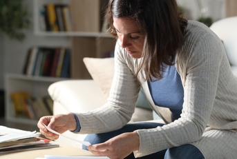 woman checking receipts at home at night