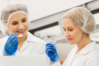 women technologists with clipboard tasting ice cream