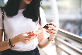 female consumer using credit card and smartphone