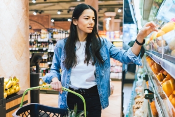 young woman doing grocery shopping in supermarket