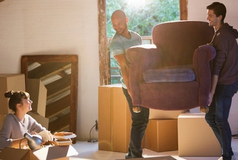 friends moving furniture in new home