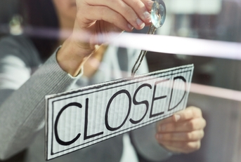 young woman hanging banner with closed word