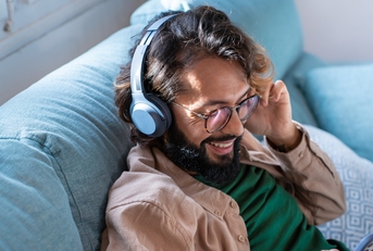 young man wearing headphones listens to mobile music