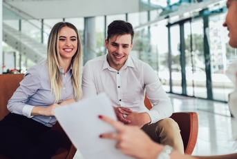 financial advisor showing report to young couple