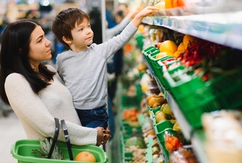 young mother with her little baby boy at the supermarket