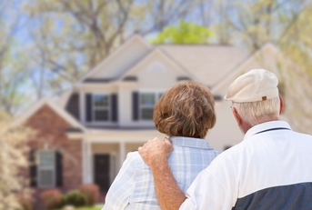 senior couple sitting at front house after retirement