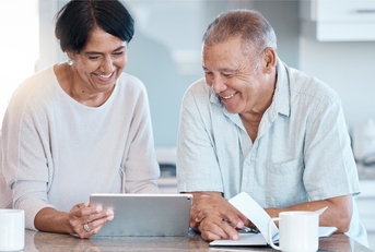 happy asian couple using tablet on countertop 