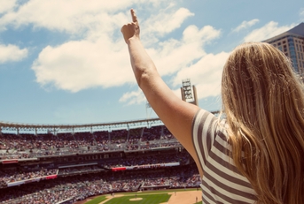 woman standing and cheering at a baseball game