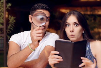 couple surprised by the  expensive restaurant bill