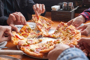 group of friends in restaurent picking out pizza slices from the table