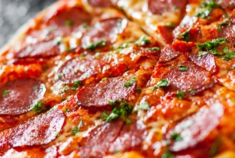 pepperoni pizza with cheese and tomato sauce, topped with aromatic basil leaves