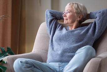 senior woman resting seated on coach