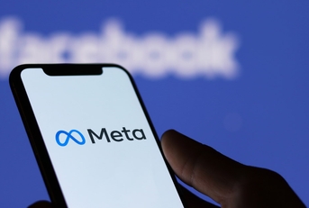 man holding smartphone with meta logo