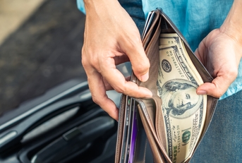 woman hands holding a wallet with dollar currency