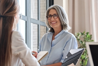 female hr manager standing in front of young female assistant at office