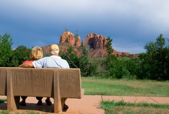 senior couple enjoying vacation while sitting on bench in arizona during day time