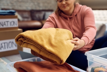 woman sorting out clothes in donation box for charity
