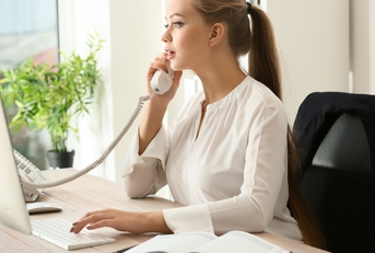 female secretary talking on telephone in office