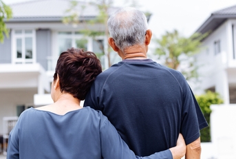 senior couple from behind looking at front of house