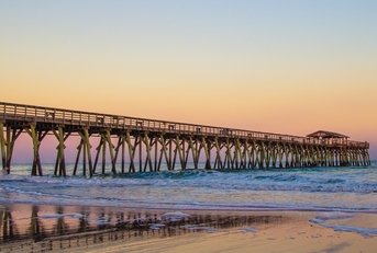 myrtle beach ocean pier with coastal tides at sunset 