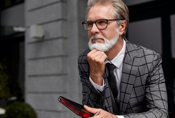 senior business man thinking while holding diary