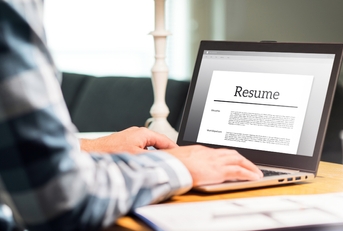 man writing resume and cv in home office with laptop