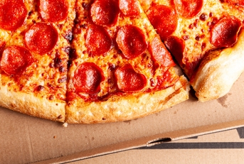close up of &#x27;Costco food court&quot; delicious fresh made pepperoni pizza sliced and placed in cardboard box