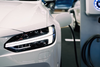 An environmentally-friendly vehicle hybrid electric car's battery is being charged by a sustainable energy source. .