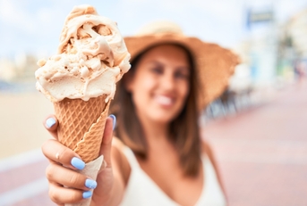 woman showcases delicious ice cream cone.