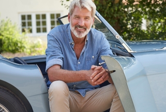 senior man in vintage sports car