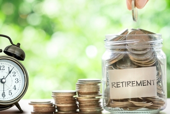 hand putting coins in glass jar