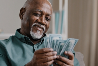 senior man counting banknotes