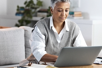 Businesswoman diligently operating her laptop.
