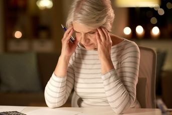 stressed senior woman filling tax form