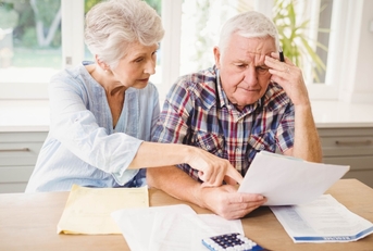 stressed senior couple reviewing bills