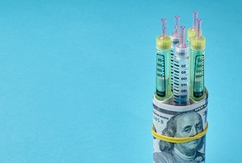 syringe pens wrapped in dollar bills