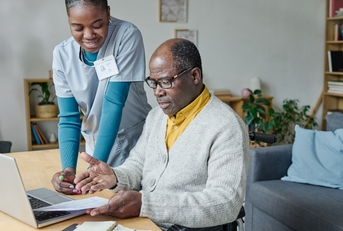 young caregiver helping senior man