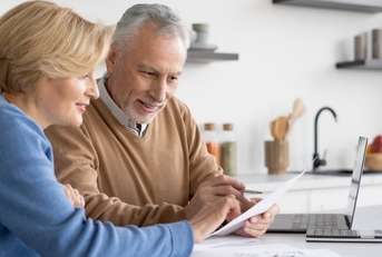 couple reviewing bills at home kitchen